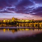 The Prague Castle and Charles Bridge at a dramatic sunset.