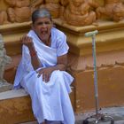 Tired old lady sitting in temple