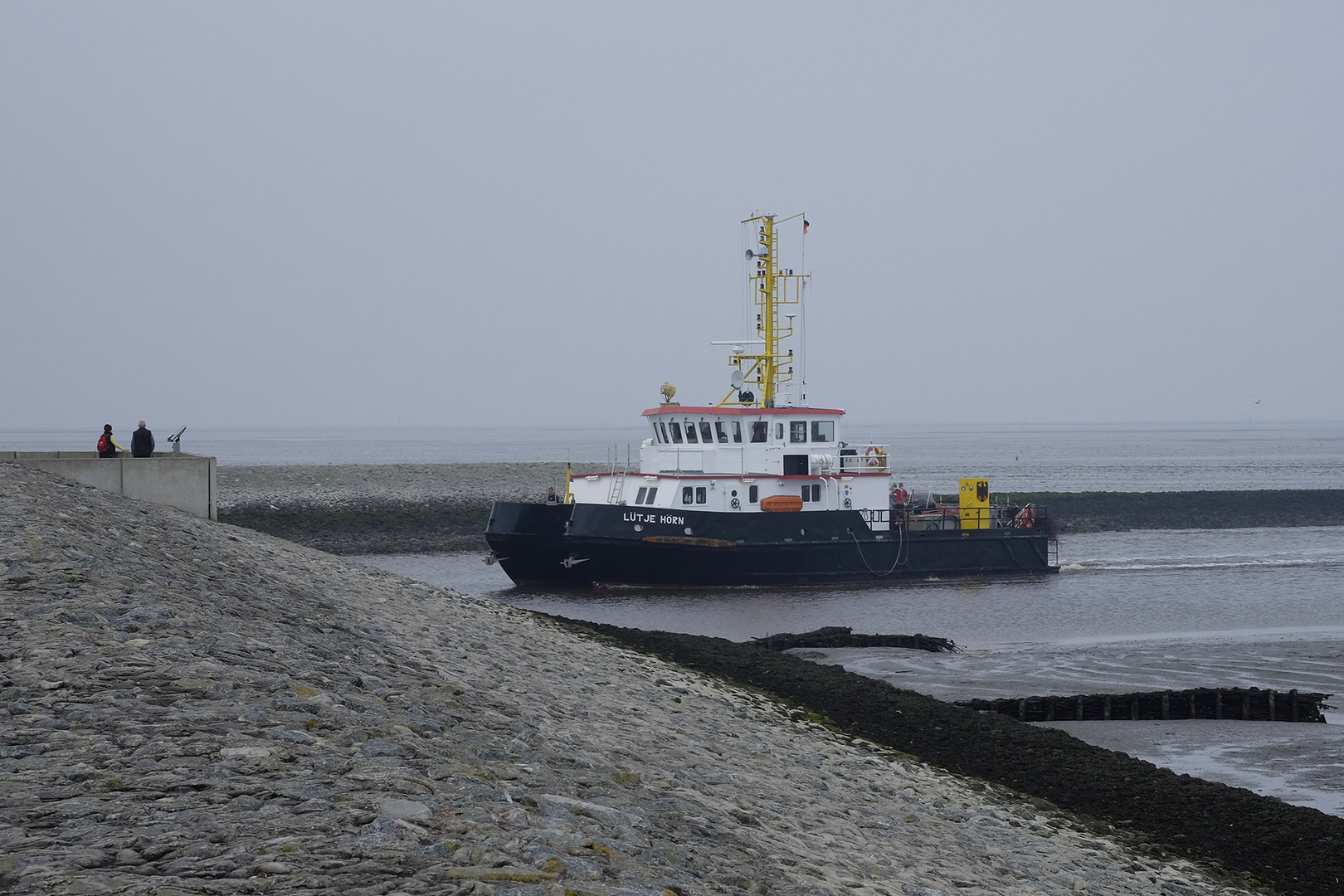 Tonnenleger "Lütje Hörn" fährt bei auflaufendem Wasser in den Hafen von Neuharlingersiel ein.