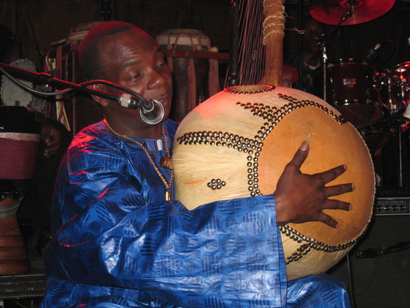 Toumani Diabaté in der Fabrik erklaert sein Instrument - die Kora