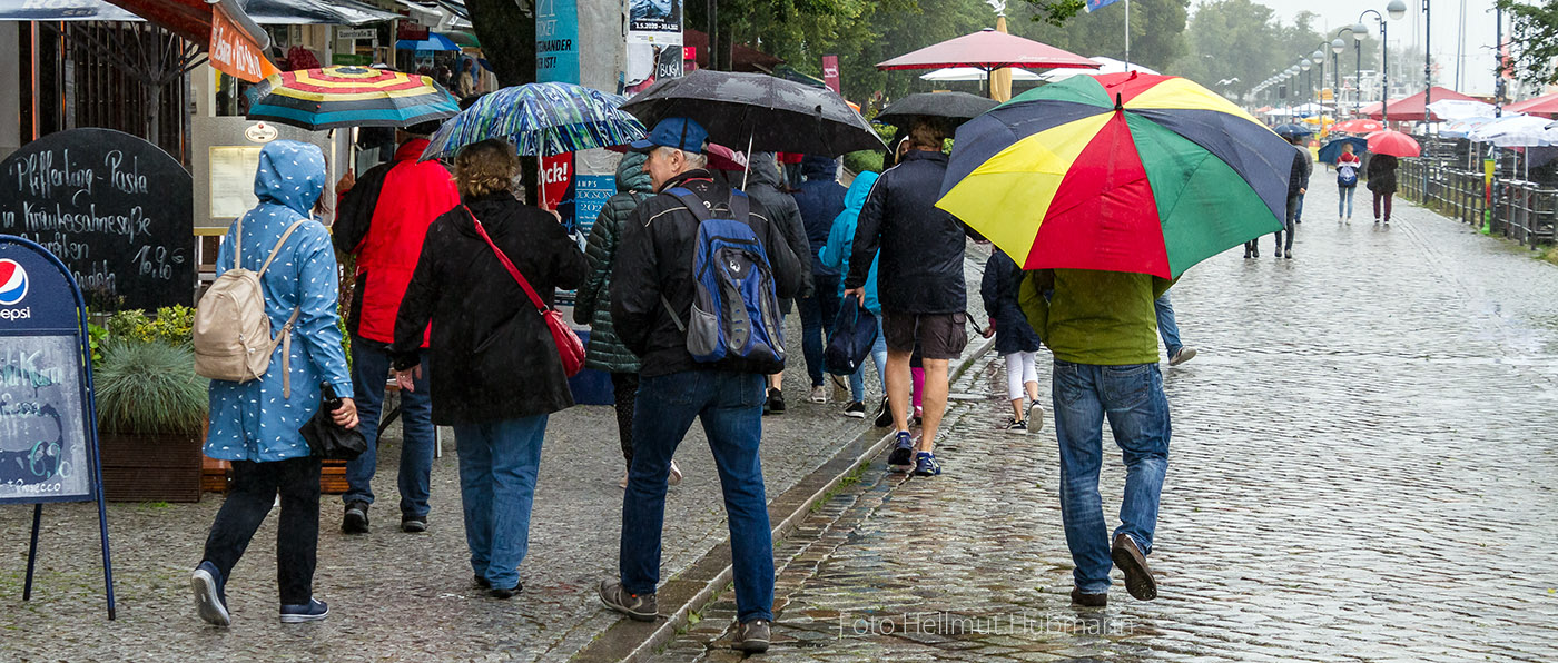 TOURIS IM REGEN AM URLAUBSZIEL