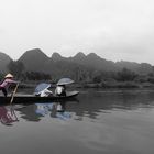 Touristen auf Langboot mit Sonnenschirm in Vietnam