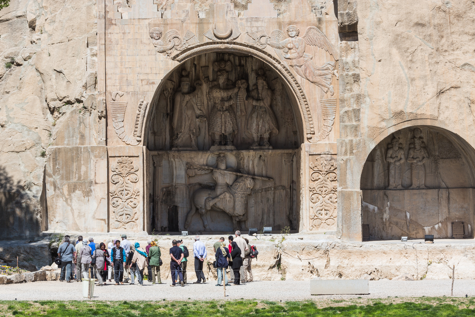 Touristen bei den Reliefgrotten von Tagh-e Bostan