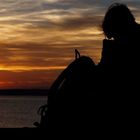 Touristin genießt den Sonnenuntergang auf der Mole von Warnemünde ..