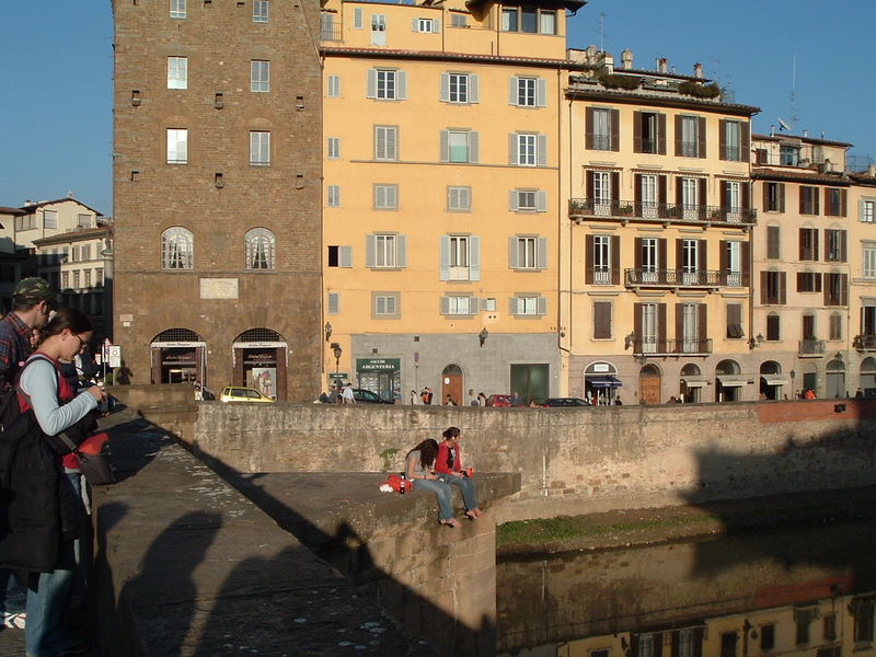 Turiste si riposano su un ponte sull'Arno