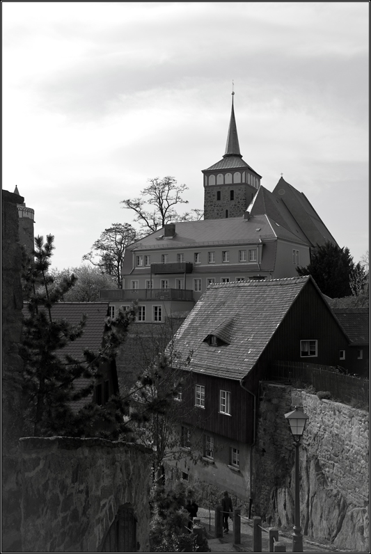 Turm auf Haus auf Haus neben Mauer