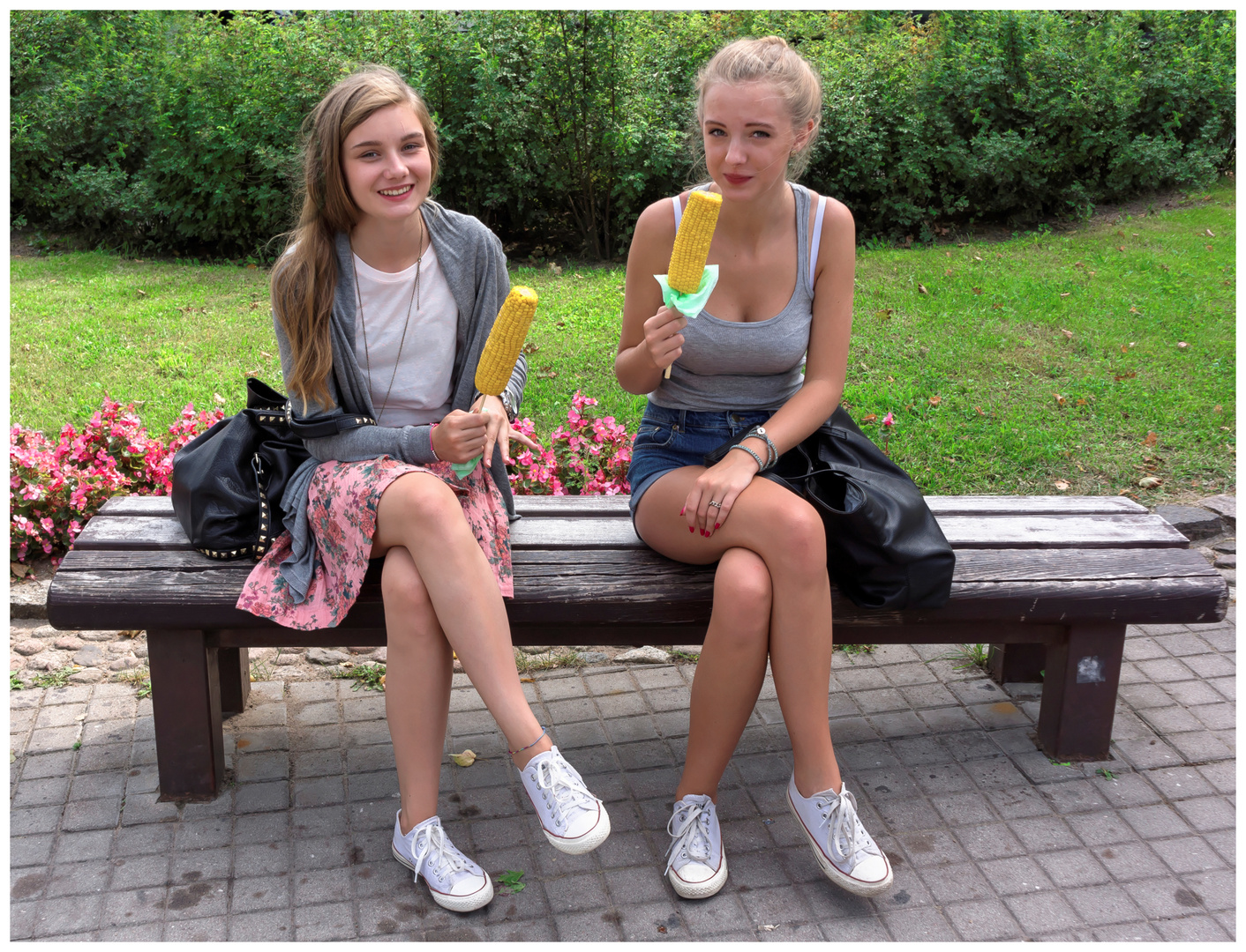 Two girls eating corncob