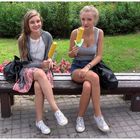 Two girls eating corncob