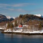 Typisch Norwegen - Rotes Haus auf einer Insel mit Bergen