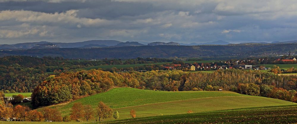 Über den bewaldeten Höhenzug bei Pirna schauen die Gipfel der Sächsischen Schweiz...