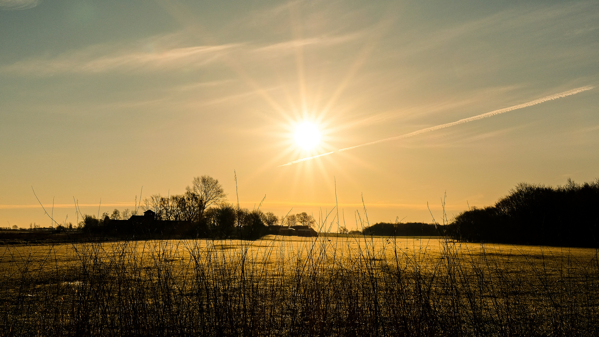 Über den Feldern geht die Sonne auf