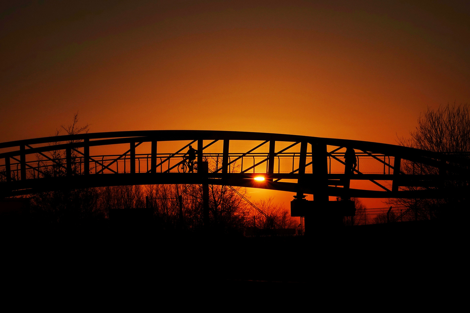 über die Brücke mit dem Fahrrad bei Sonnenuntergang