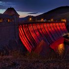 Überlaufende Edertalsperre in der roten Illumination.