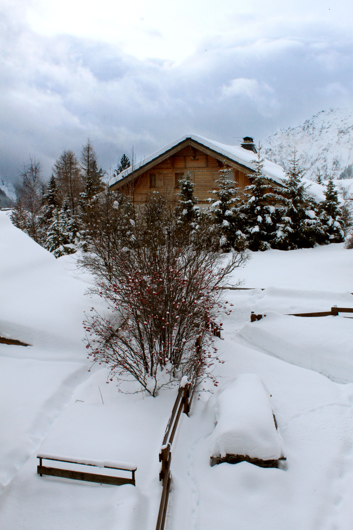 Un chalet isolé sous la neige et les nuages