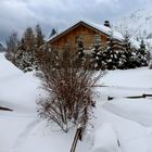 Un chalet isolé sous la neige et les nuages