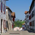 Une rue d’Espelette : vue sur les contreforts pyrénéens et l’incontournable fronton de pelote basque