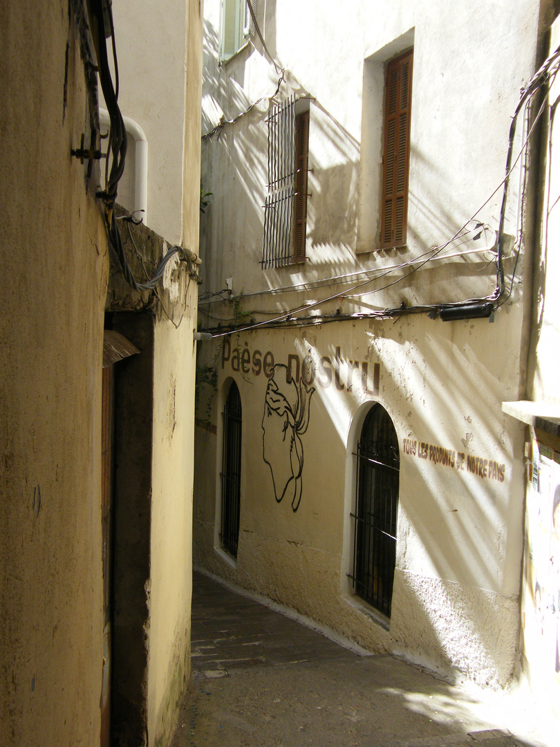 une ruelle d ajaccio qui mene à un restaurant caché entre deux immeubles