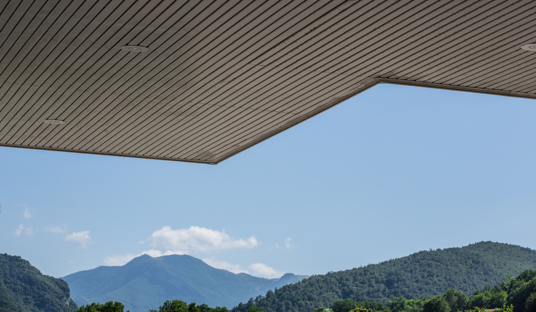 unter dem Dach einer Tankstelle -Durchblick in die Berge