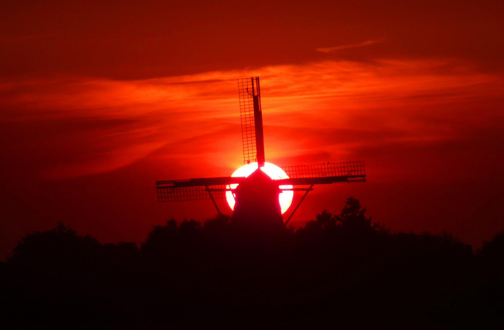 Untergang der Sonne hinter der alten Windmühle von Cadzand