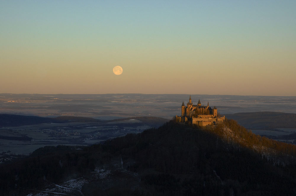 untergehender Vollmond bei aufgehender Sonne