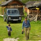 Urgrossvater und sein Enkel auf der Alm bei der Arbeit