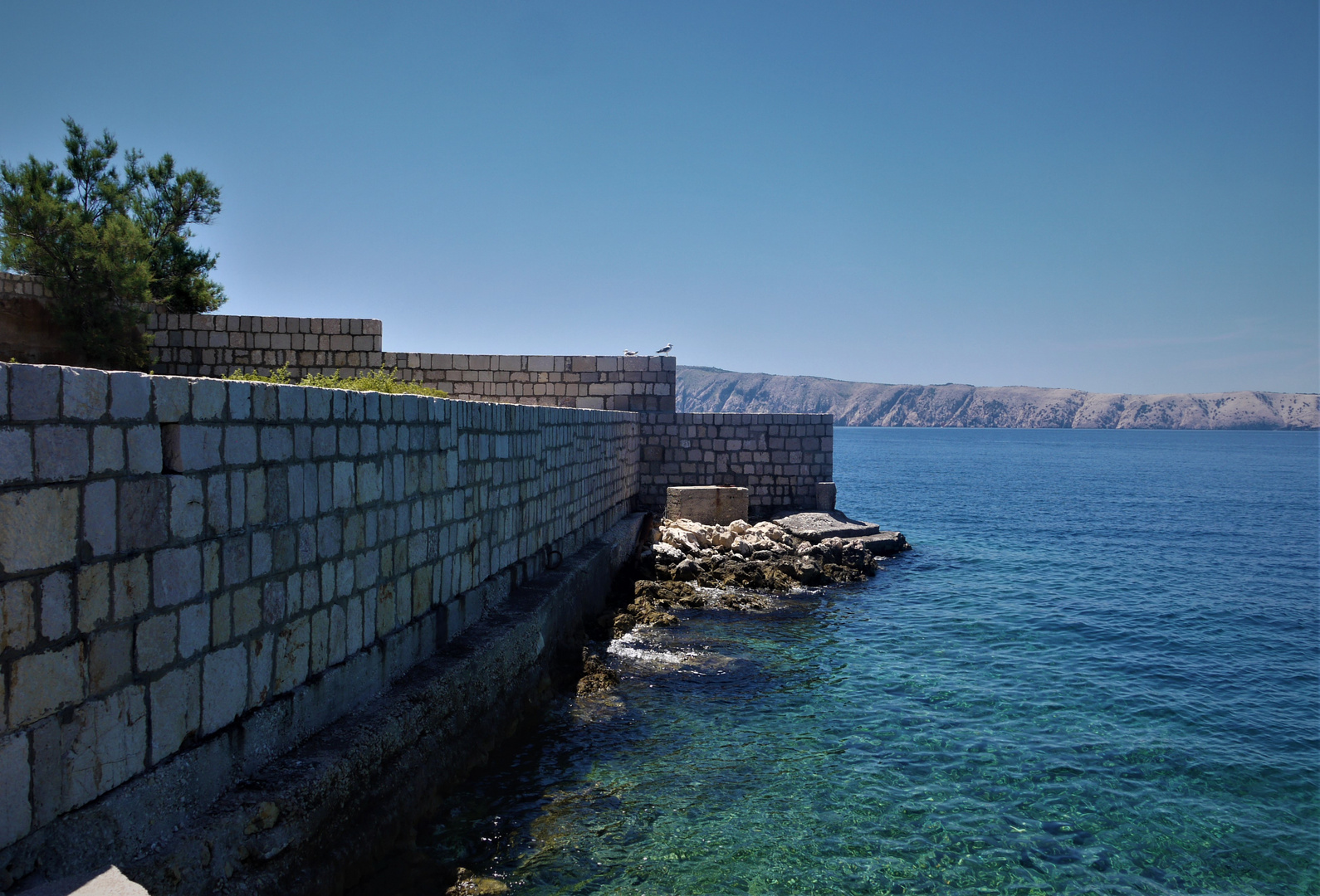 Urlaub 2018 auf der Insel Rab - Befestigungsmauer der Insel Goli Otok und Blick auf den Kamenjak