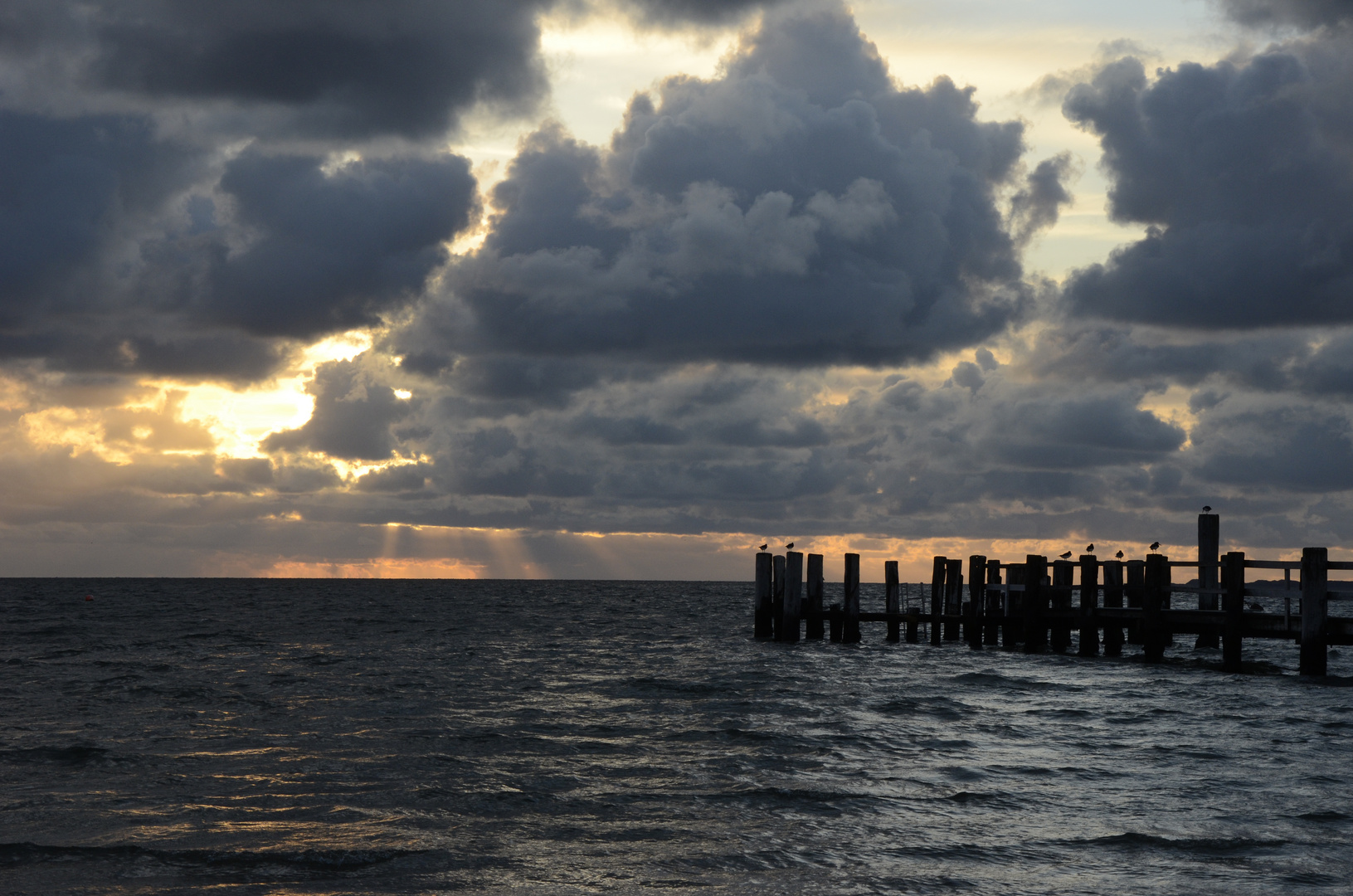 Utersumer Strand am Abend, die Sonne verschwindet hinter den Wolken