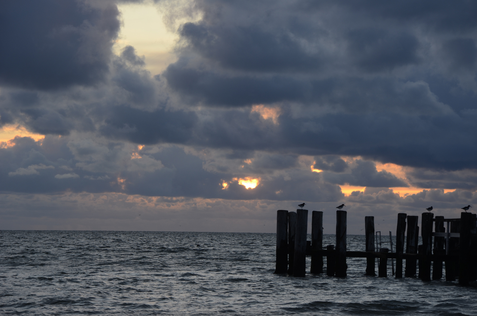 Utersumer Strand am Abend, die Sonne verschwindet hinter den Wolken