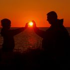 Vater mit Tochter beim Sonnenuntergang