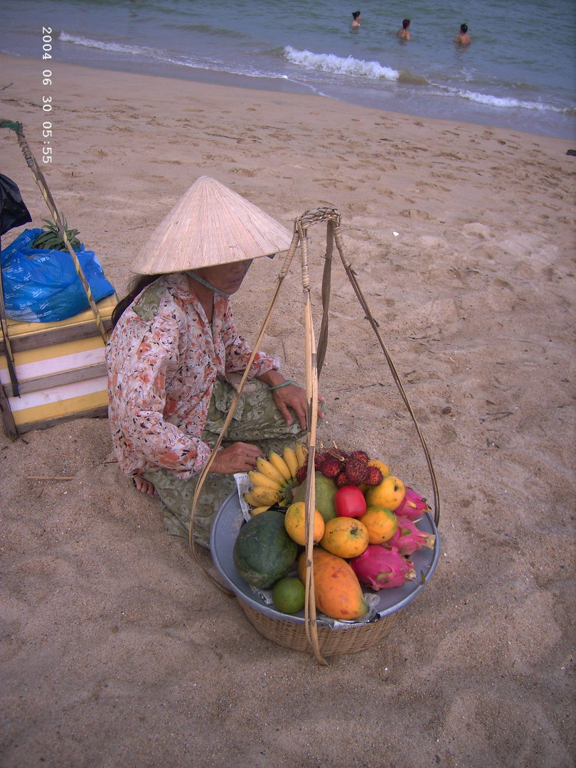 Vendeuse de fruits sur la plage . La mer de Chine .