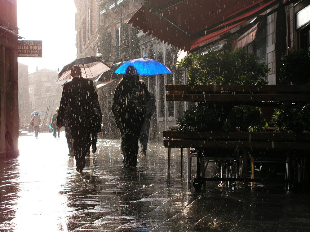 Venedig-Regen, Sonne, blauer Schirm