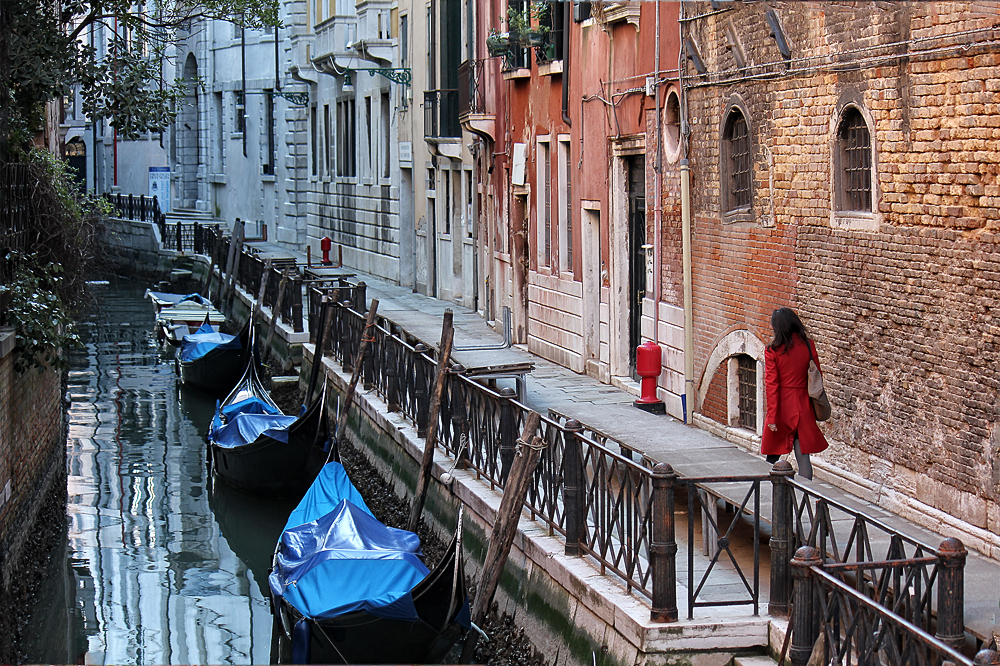 Venise, la jeune fille en rouge au bord du canal