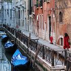 Venise, la jeune fille en rouge au bord du canal