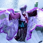 Verkleidete Frau mit violetten Flügeln