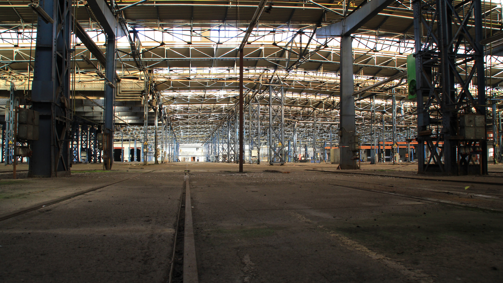 Verlassene Stahlhalle mit Schienen