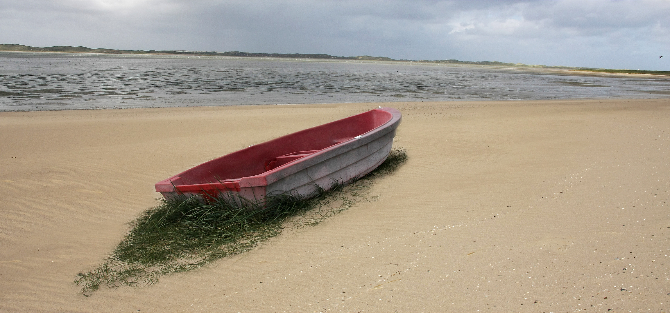 Verlassenes kleines Boot am Strand vom Ellenbogen