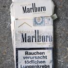 Verwitterte Marlboro Zigarettenschachtel auf Granit