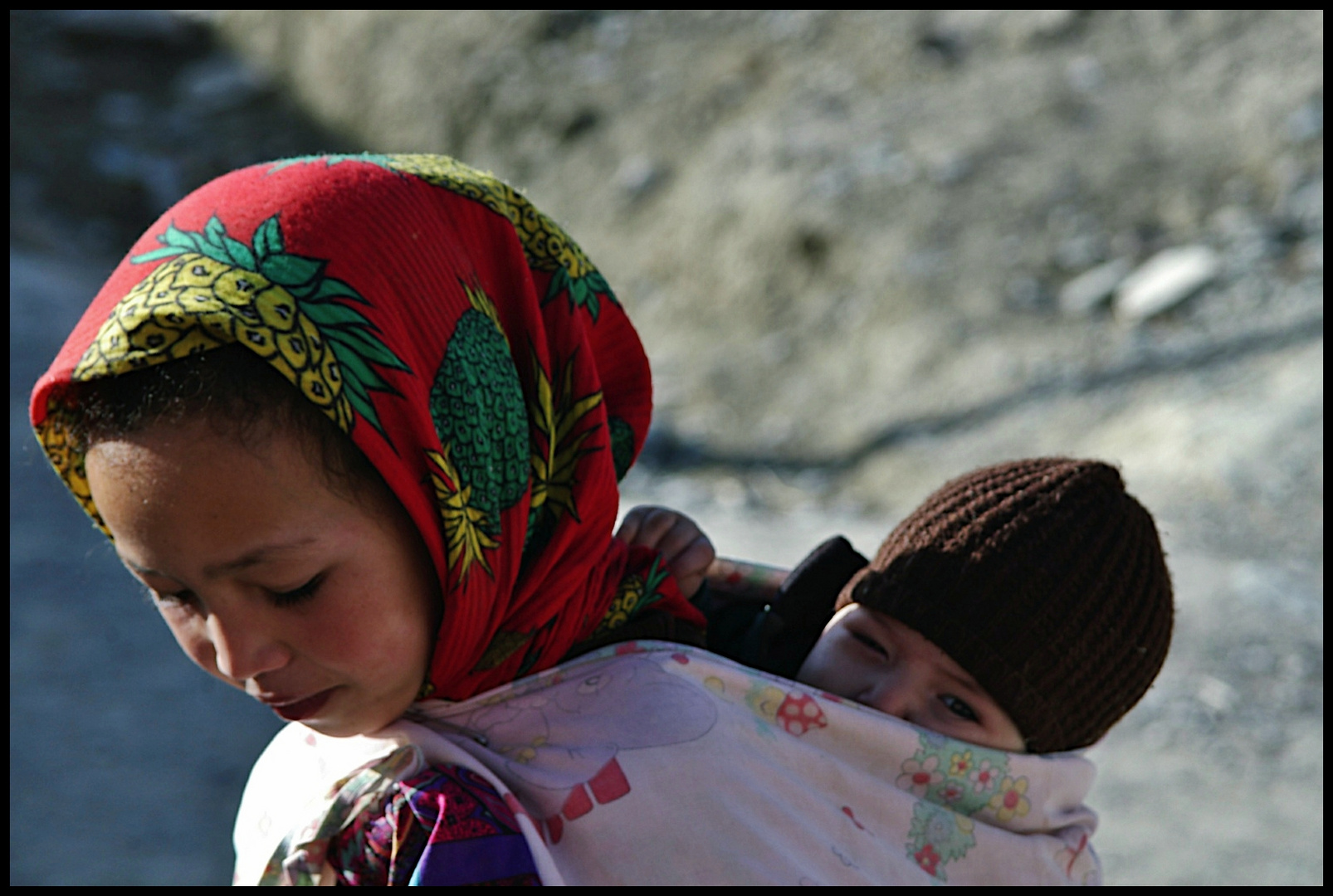 Very young girl and little brother on the back