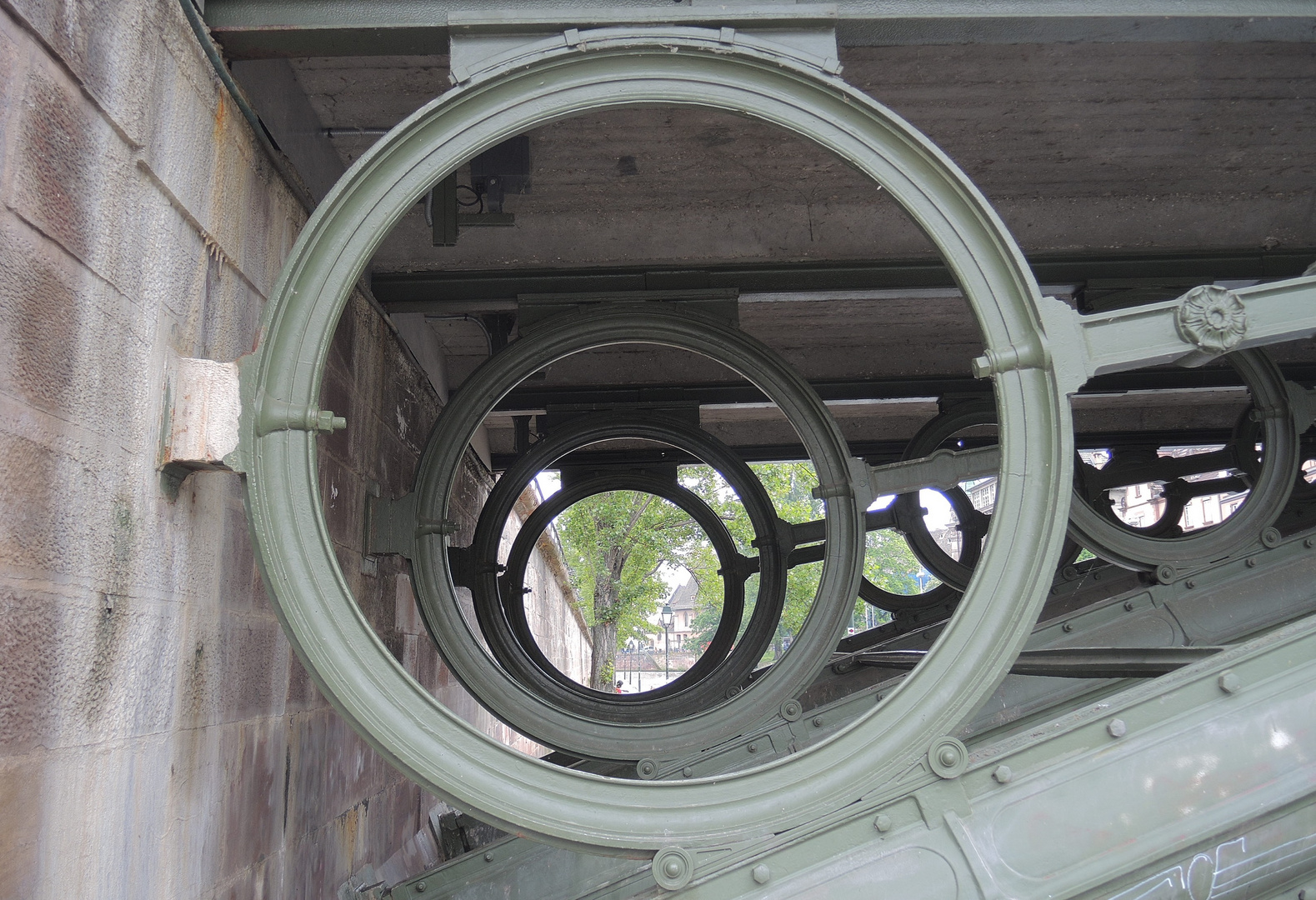 View through cast iron round construction elements of historic Ill river bridge in Strasbourg