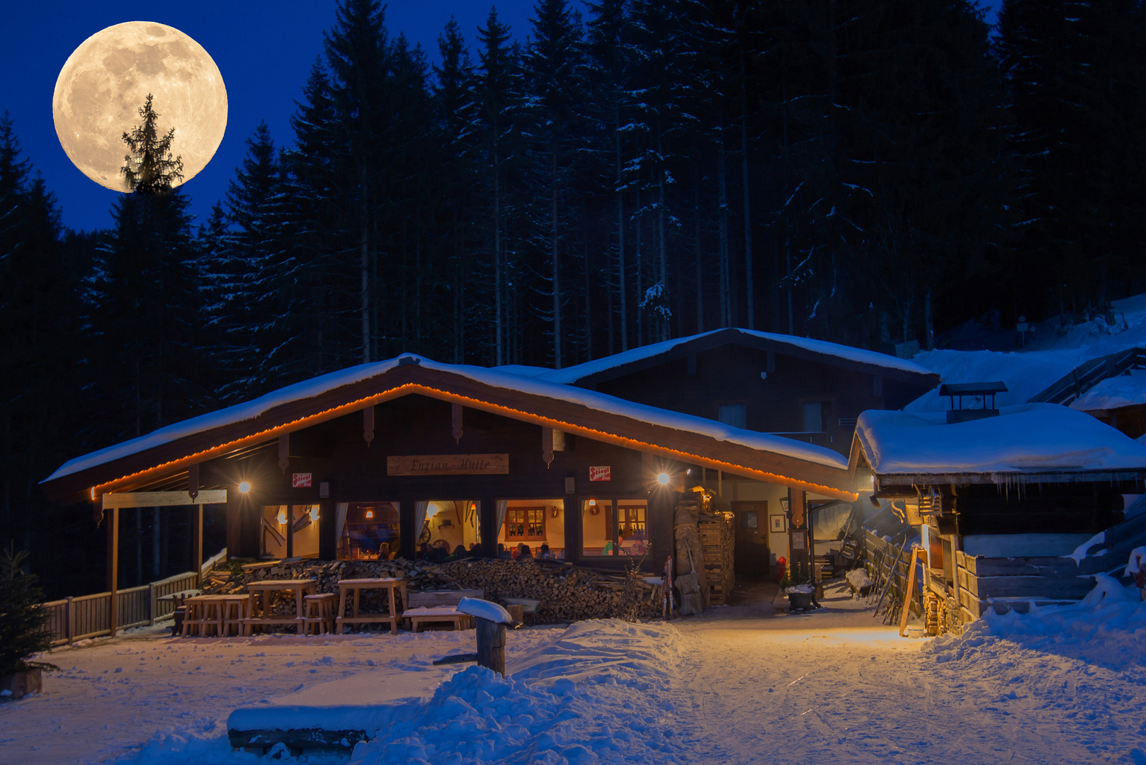 Vollmond über einer Hütte im Winter.