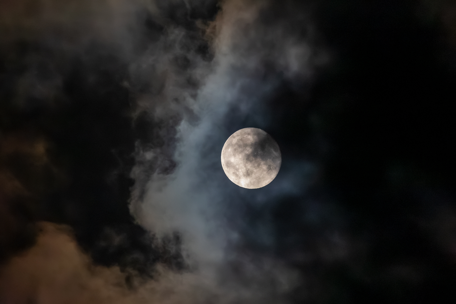 Vom Mond ins rechte Licht gerückte Wolken