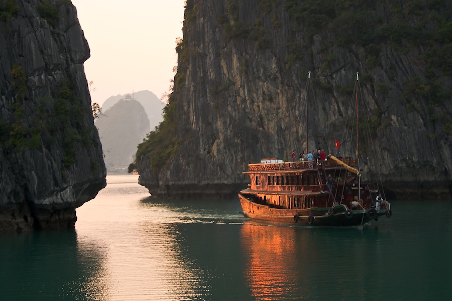 Von der Abendsonne angestrahltes Boot in der Ha Long Bucht