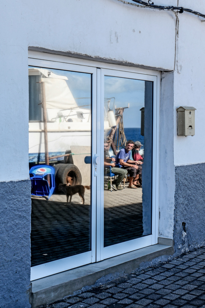 Vor dem Boot herumsitzende Menschen und Hund