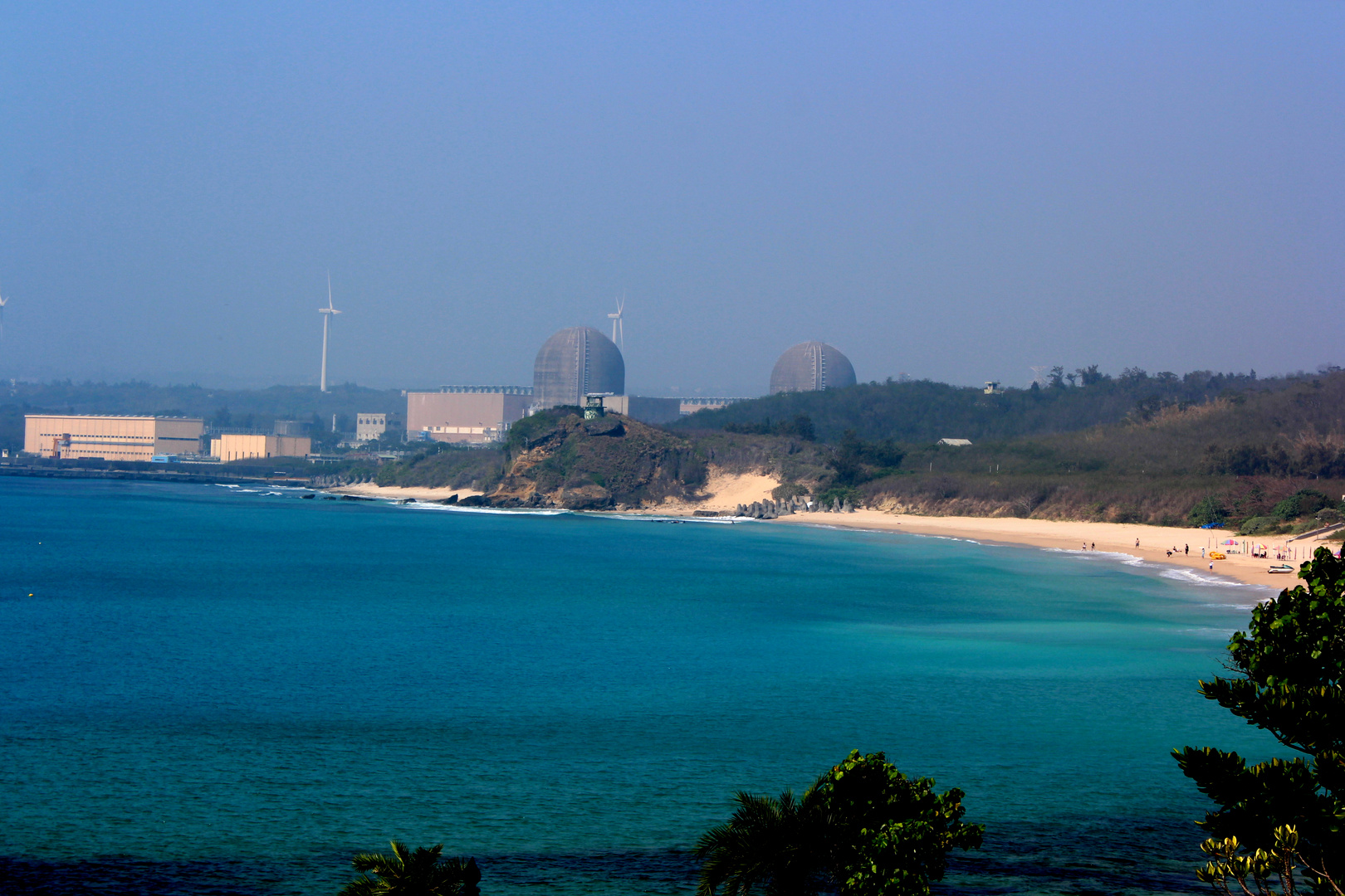 Vordergrund: Strand, Hintergrund Atomkraftwerk