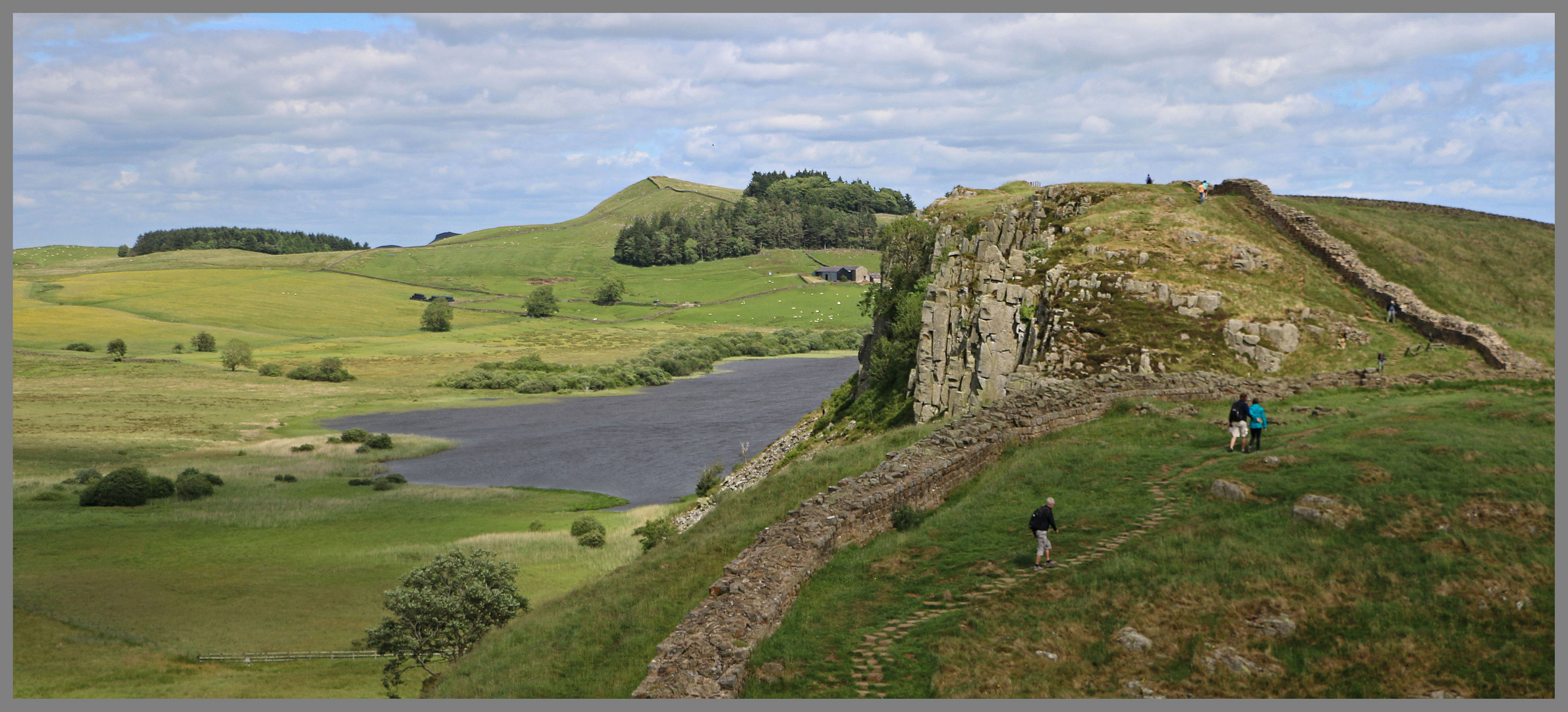 walkers beside crag lough Hadrians Wall