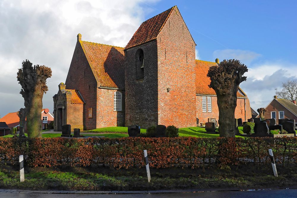 Warftkirche von Critzum (Rheiderland) an der unteren Ems mit freistehendem schiefen Turm