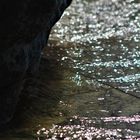 Wasser umspült den Stein , und die Sonne kokettiert mit dem Wasser