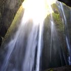 Wasserfall fällt in eine kleine begehbare Höhle auf Island