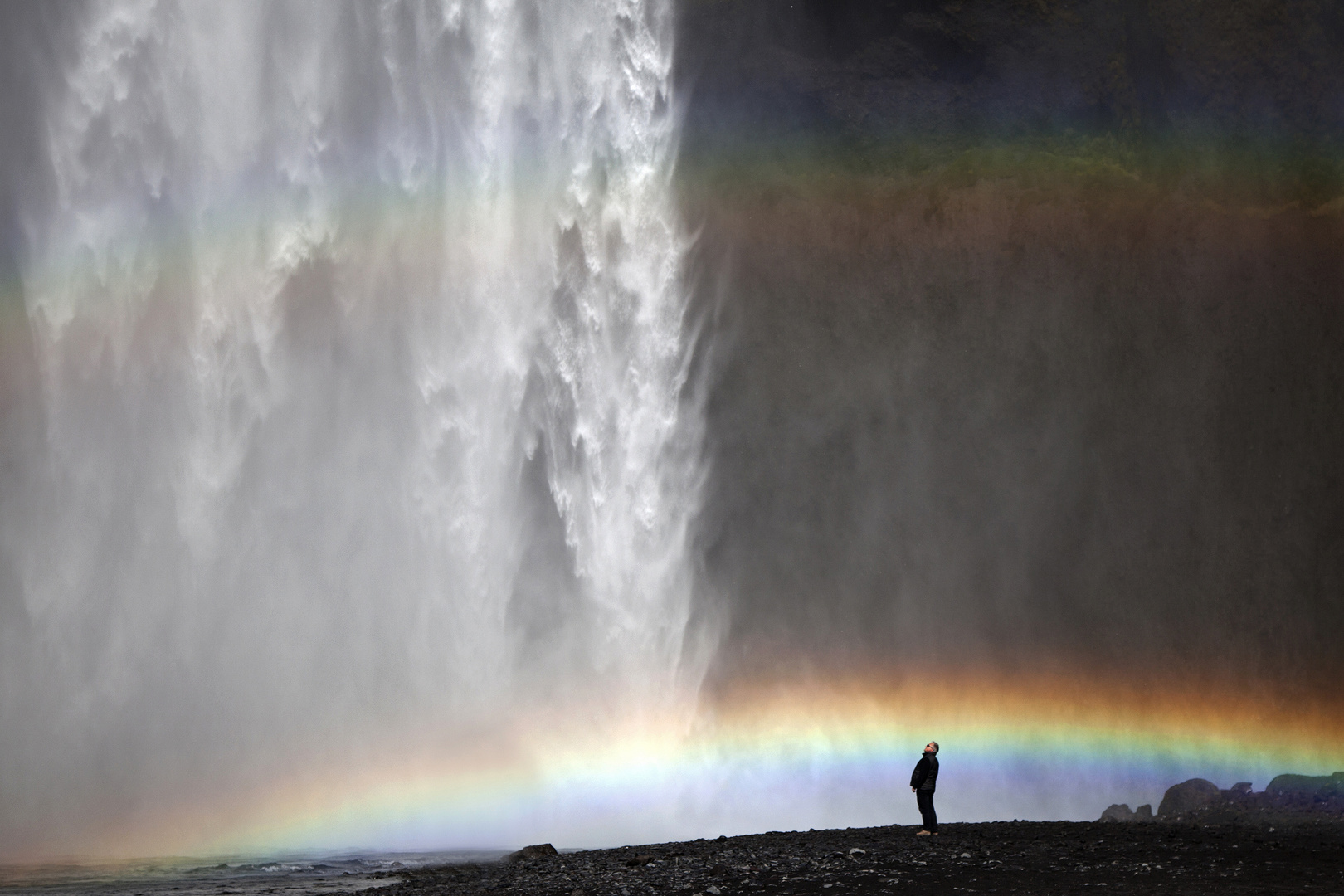 Wasserfall mit Regenbogen und Mensch