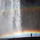 Wasserfall mit Regenbogen und Mensch